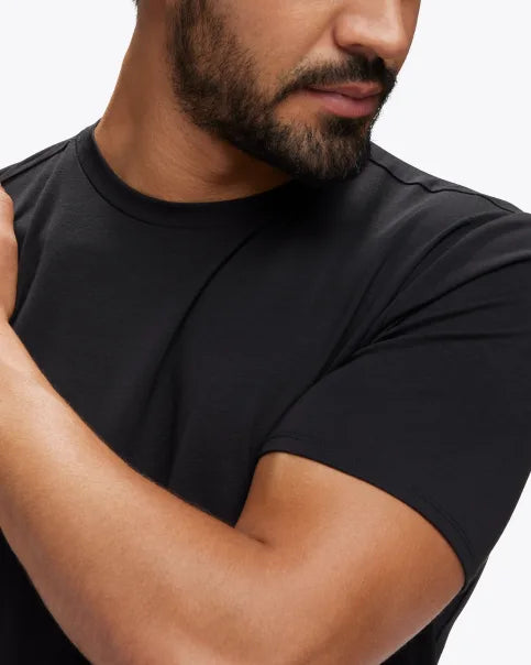 Extremt mjuk och bekväm T-Shirt i svart färg. Liten Hoka logo i mitten av skulderbladen i en grå färg. Denna tröja har en smal passform men den är inte tight.