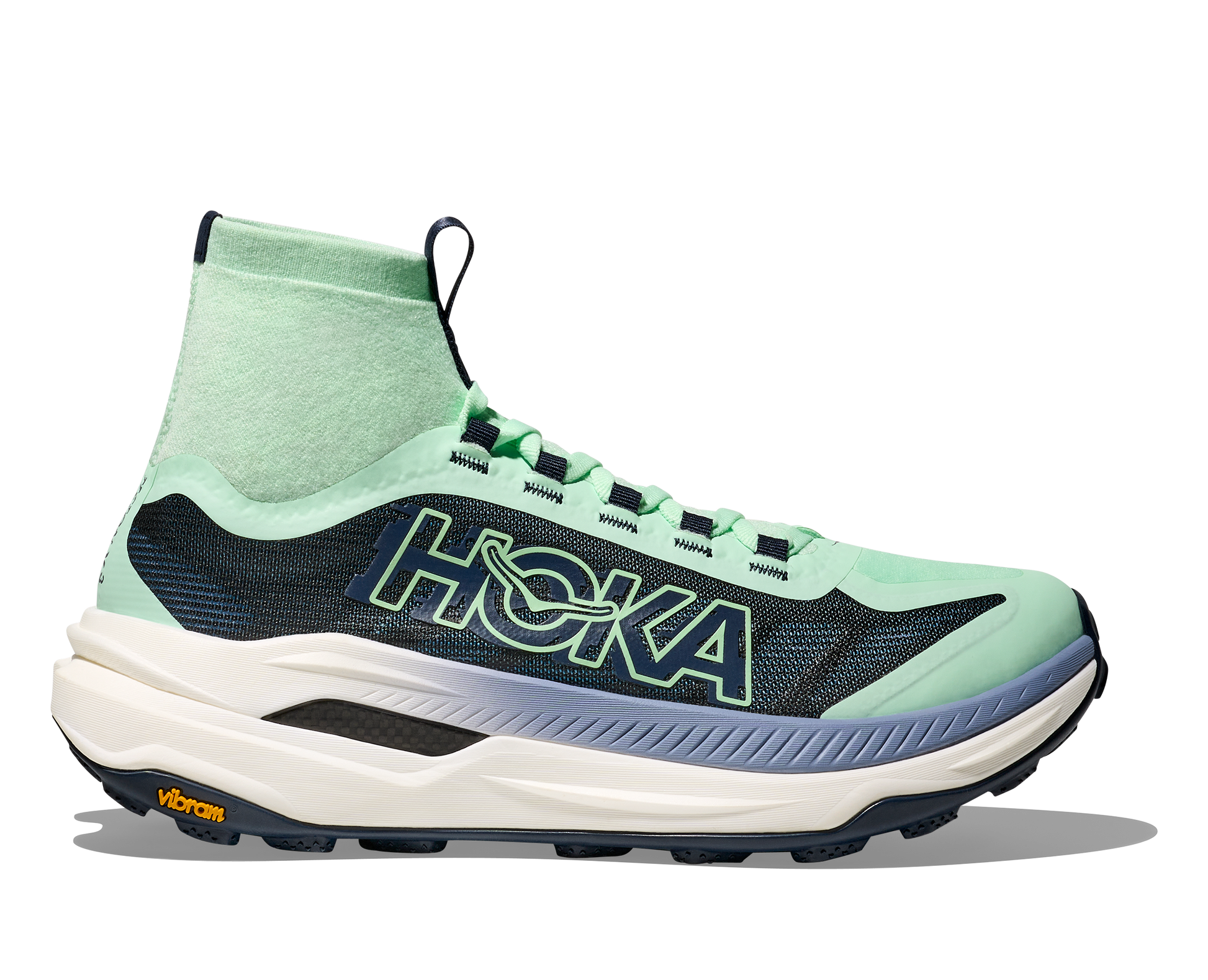 Hoka Tecton X 3 W , dammodell. En av marknadens snabbaste trailsko med en delad kolfiberplatta. Strump-design för att skydda fötterna ifrån smuts och skräp. Färgen går i grönt och svart med vit sula och små detaljer i andra färger. 